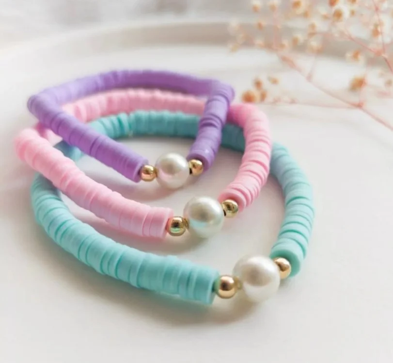 Pastel clay bead bracelet stack in soft pink and lavender tones, trendy aesthetic handmade jewelry for teens