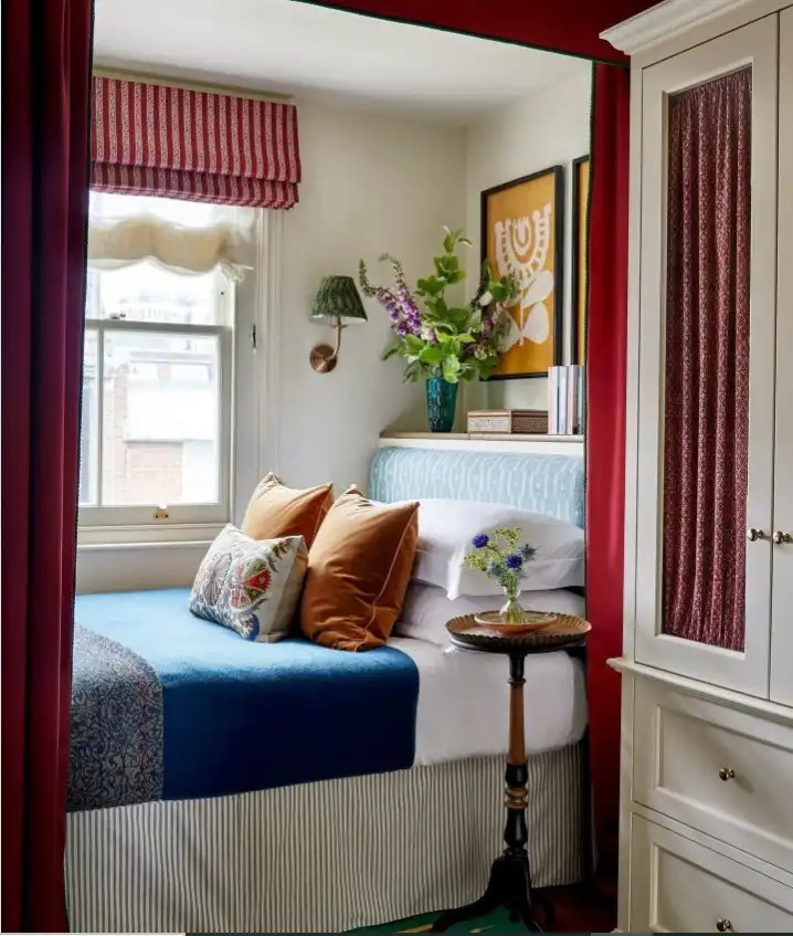 Bold vintage feminine bedroom ideas with red curtains, green rug, and dramatic antique accents