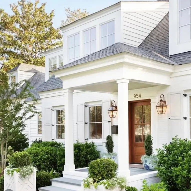 bungalow front porch with potted plants and flower containers