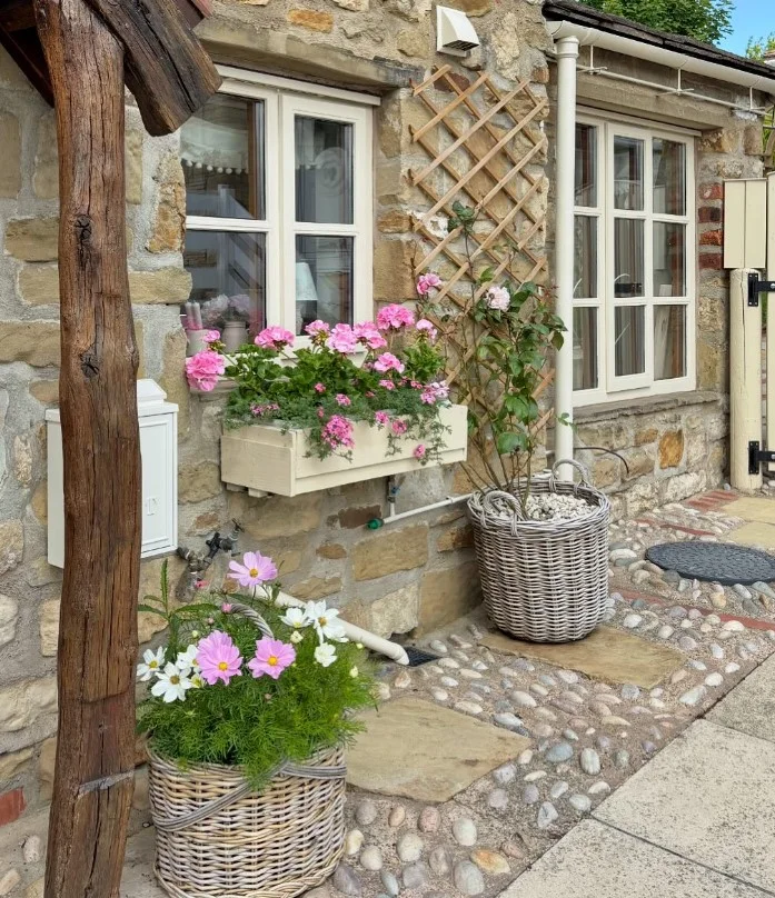 cottage front porch with window boxes full of flowers