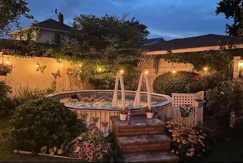 warm string lights around above ground pool deck