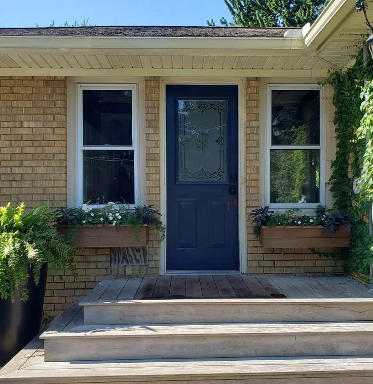 bold black front door on small front deck
