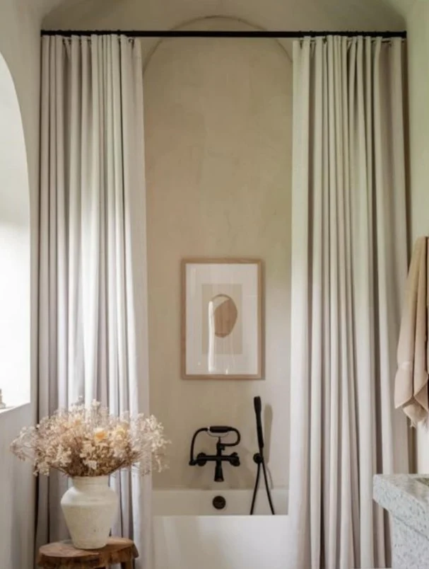 white shower curtain with black curtain rod and fixtures