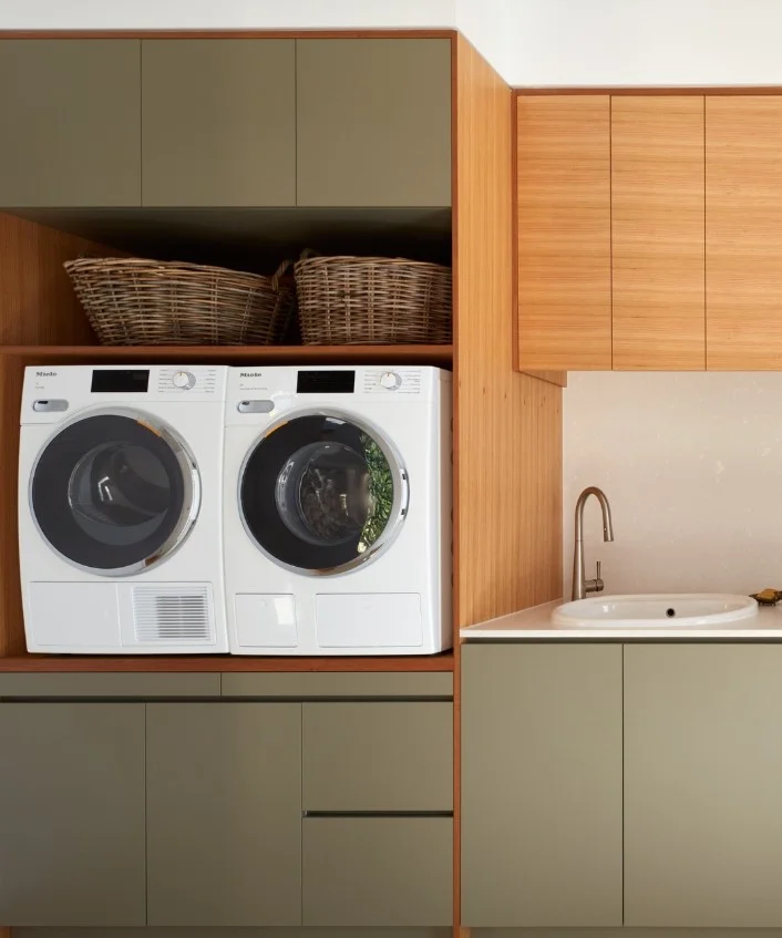 built in laundry room cabinets surrounding washer and dryer